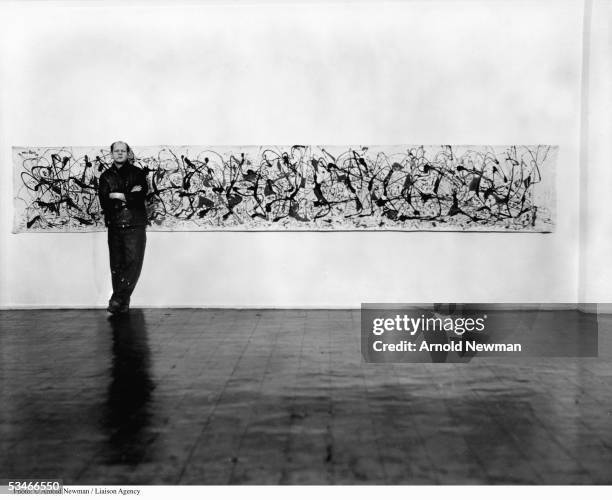 Abstract Expressionist painter Jackson Pollock poses for portrait next to painting January 3, 1949 in New York.