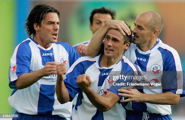 Marcel Schied celebrates scoring the first goal with Antonio Di Salvo and Magnus Arvidsson of Rostock during the Second Bundesliga match between...