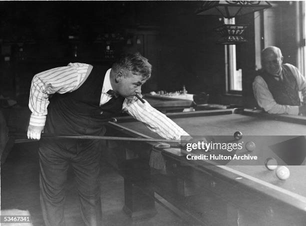 American newspaper columnist and humorist Don Marquis smokes a cigar as he plays a game of pool, 1920s. Marquis was the creator of the characters...