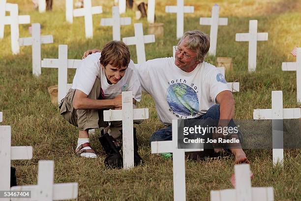 Diane Baker from Dallas, Texas and Bob Oehmen from Chicago, Illinois spend a moment together among crosses setup to represent soldiers who have died...