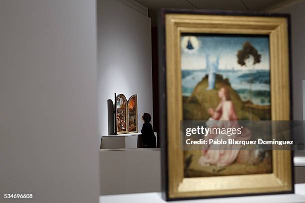 Woman looks at 'The Last Judgement Triptych' by Dutch painter Hieronymus Bosch during a press preview of the 'El Bosco' 5th Centenary Anniversary...