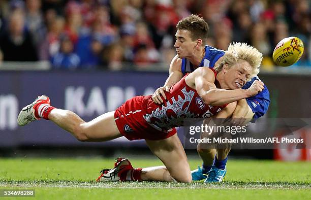 Isaac Heeney of the Swans is tackled by Shaun Atley of the Kangaroos during the 2016 AFL Round 10 match between the Sydney Swans and the North...