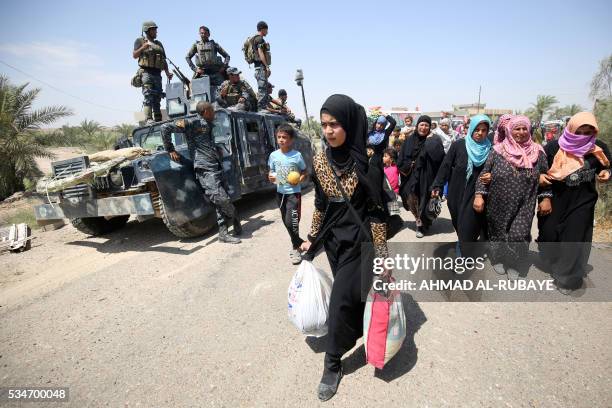 Iraqi families are pictured near al-Sejar village, in Iraq's Anbar province, after fleeing the city of Fallujah, on May 27 during a major operation...