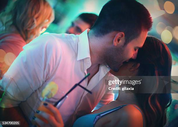 group of young adults on double date in a club. - woman whisper to man stockfoto's en -beelden