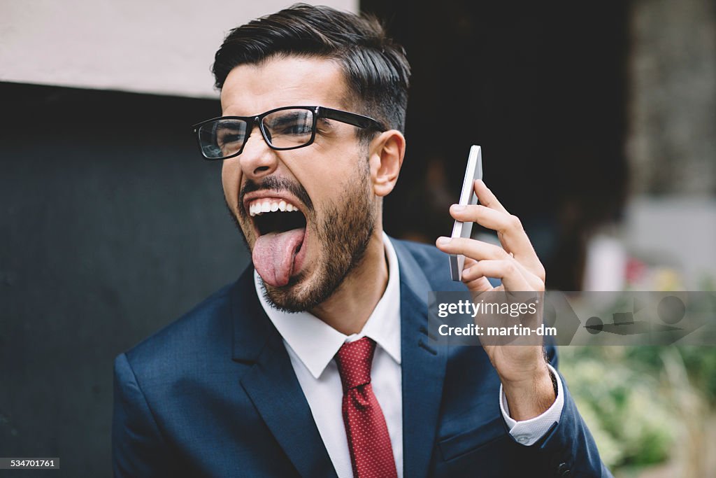 Businessman sticking out tongue at the street