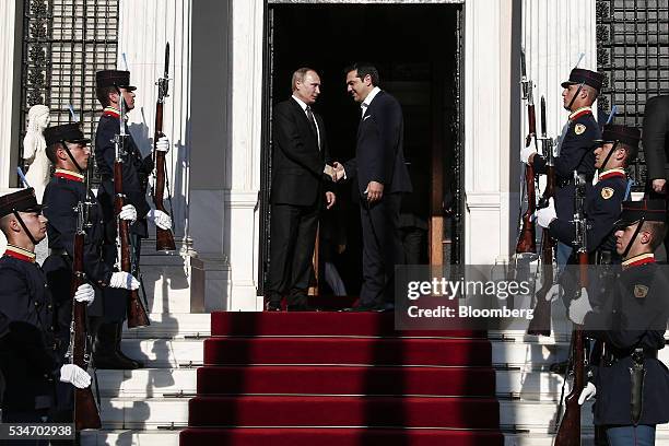 Alexis Tsipras, Greece's prime minister, right, shakes hands with Vladimir Putin, Russia's president, at Maximos Mansion in Athens, Greece, on...