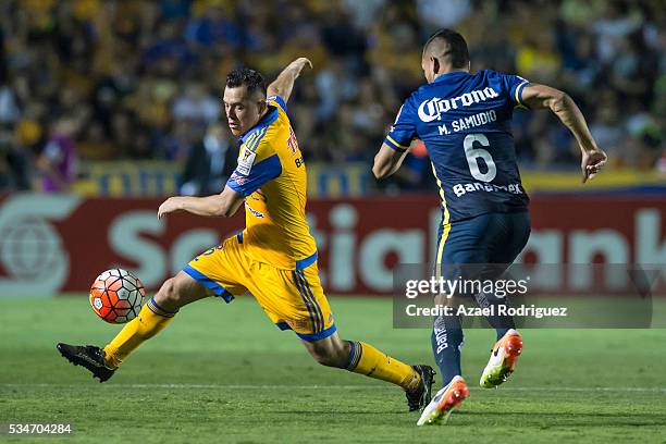 Israel Jimenez of Tigres fights for the ball with Miguel Samudio of America during the Final first leg match between Tigres UANL and America as part...
