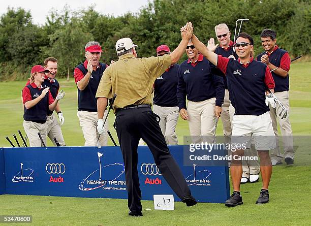 Michael Chang of the USA leads the American team as they react to the shot of their captain Mark O'Meara of the USA, during the Nearest the Pin...