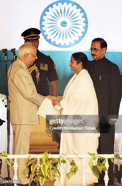 West Bengal Chief Minister Mamata Banerjee shaking hands with the Governor Kesri Nath Tripathi after taking oath at Red Road on May 27, 2016 in...