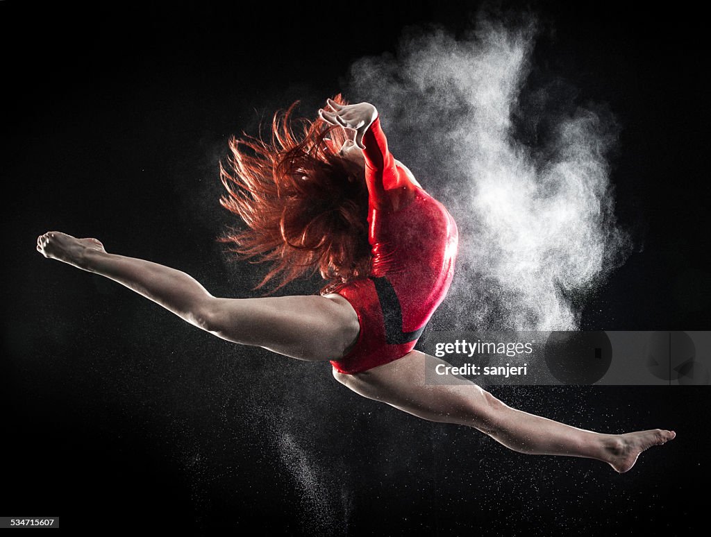 Young woman doing gymnastics jump