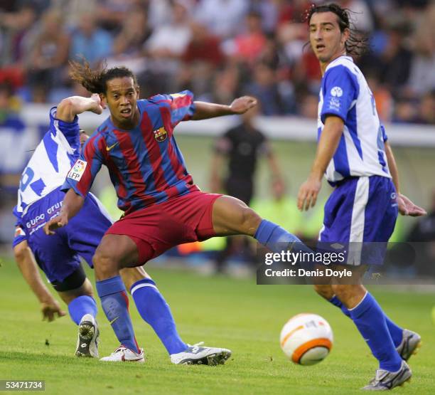 Ronaldinho of F.C Barcelona tries to get past Jandro of Alaves during a Primera Liga soccer match between Alaves and F.C. Barcelona at the Estadio...