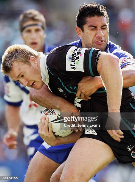 Shane Rodney of the Panthers is tackled by Jamaal Lolesi of the Bulldogs during the round 25 NRL match between the Bulldogs and the Penrith Panthers...