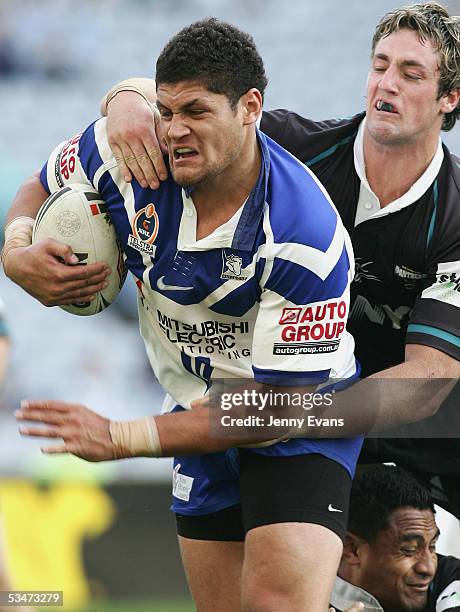 Willie Mason of the Bulldogs is tackled by Trent Waterhouse of the Panthers and Joe Guluvao of the Panthers during the round 25 NRL match between the...
