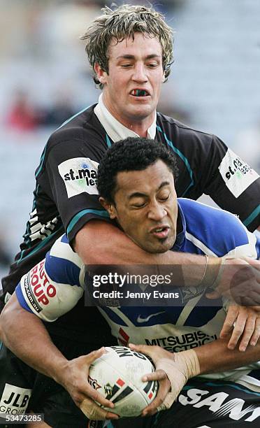 Roy Asotasi of the Bulldogs tackled by Trent Waterhouse of the Panthers during the round 25 NRL match between the Bulldogs and the Penrith Panthers...
