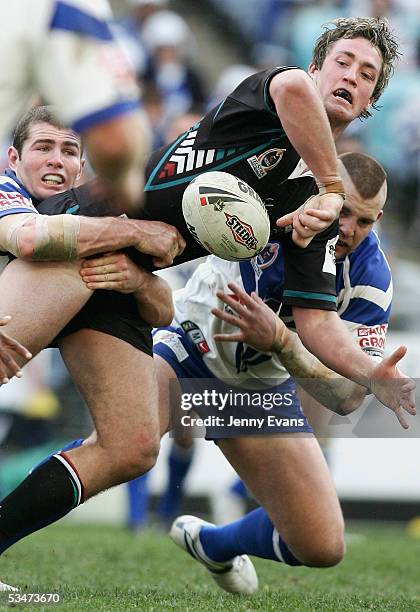 Trent Waterhouse of the Panthers tackled by Andrew Ryan of the Bulldogs and Mark O'Meley of the Bulldogs during the round 25 NRL match between the...