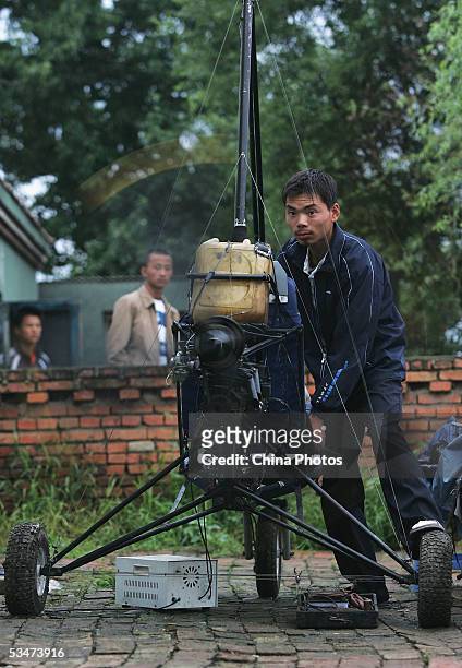 Chinese farmer Wang Qingliang checks his home-made plane at the Fenghuangtuo Village on August 26, 2005 in Xiangshui Township of Gongzhuling City,...