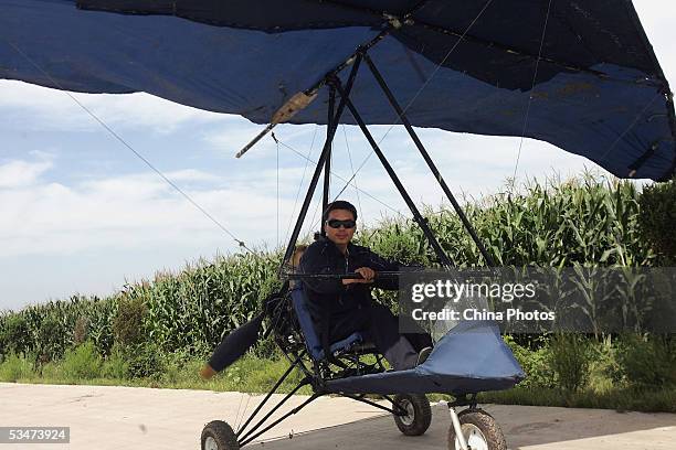 Chinese farmer Wang Qingliang prepares to start his home-made plane at the Fenghuangtuo Village on August 27, 2005 in Xiangshui Township of...