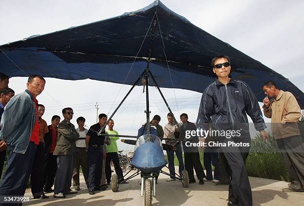 Chinese farmer Wang Qingliang prepares to start his home-made plane at the Fenghuangtuo Village on August 27, 2005 in Xiangshui Township of...