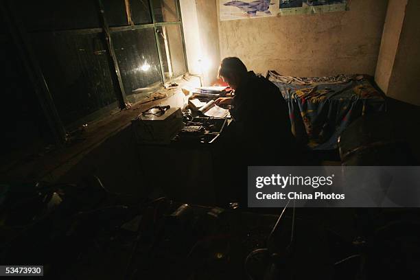 Chinese farmer Wang Qingliang studies mechanism informations at his workshop where his home-made plane is built, at the Fenghuangtuo Village on...