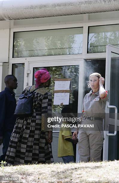 Red Cross member welcomes people at a gymnasium, 28 August 2005 in Paris, a day after seventeen people including fourteen children died and 30 were...