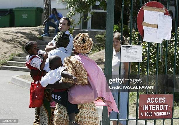 Women enter a gymnasium, 28 August 2005 in Paris, a day after seventeen people including fourteen children died and 30 were injured when a fire...