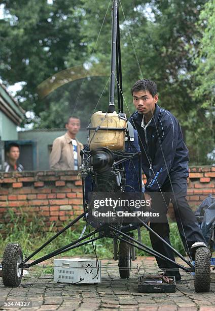 Chinese farmer Wang Qingliang checks his homemade plane at the Fenghuangtuo Village August 26, 2005 in Xiangshui Township of Gongzhuling City, Jilin...