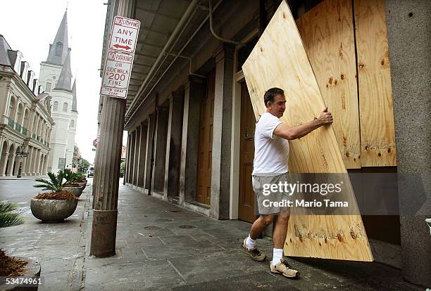 Marco Garcia helps board up a storefront in the French Quarter in preparation for Hurricane Katrina August 28, 2005 in New Orleans, Louisiana....