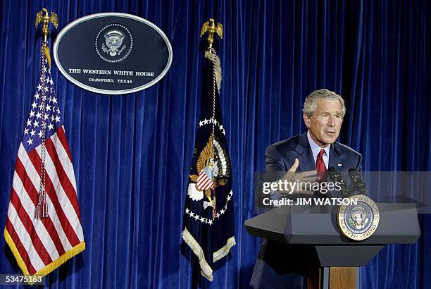 Crawford, UNITED STATES: US President George W. Bush speaks to reporters from his hangar at his Crawford, Texas, ranch 28 August, 2005. Bush on...