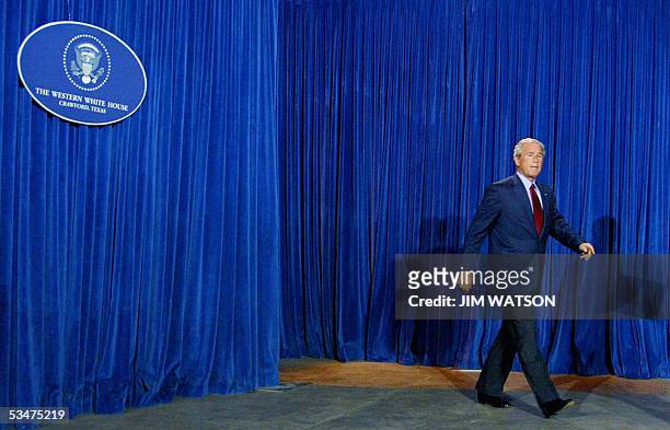 Crawford, UNITED STATES: Correction-US President George W. Bush arrives to speak to reporters from his hangar at his Crawford, Texas, ranch 28...