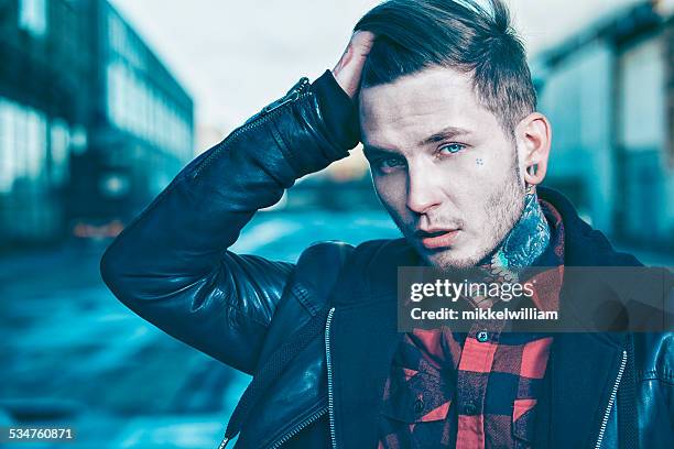 cool young man with tattoos wears leather jacket - ruffled hair stock pictures, royalty-free photos & images