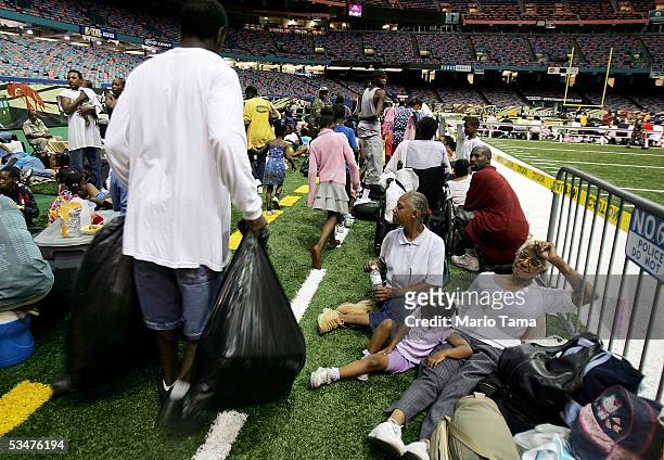 New Orleans residents sit in the Superdome, which is being used as an emergency shelter, before the arrival of Hurricane Katrina August 28, 2005 in...