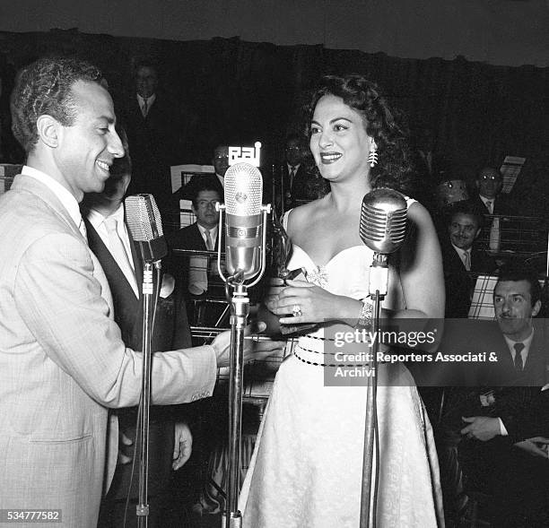 Italian actor Silvio Noto awarding Greek-born Italian actress Yvonne Sanson with the Vittorie cinematografiche award. Rome, 10th June 1954