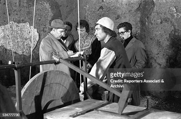 Italian director Roberto Rossellini supervising the shooting of the documentary The Iron Age, directed by his son Renzo, smoking the pipe. 1965
