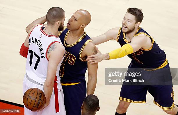 Jonas Valanciunas of the Toronto Raptors and Richard Jefferson of the Cleveland Cavaliers exchange words as Matthew Dellavedova holds back Jefferson...