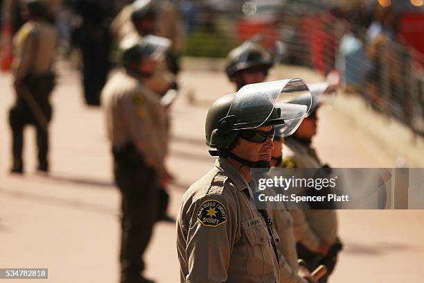 Police watch as demonstrators protest outside of an arena where the presumptive Republican presidential candidate Donald Trump is holding a rally in...
