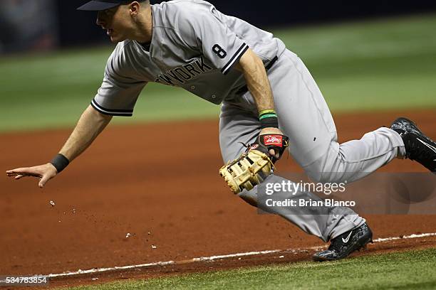 First baseman Dustin Ackley of the New York Yankees fields the ground out by Logan Morrison of the Tampa Bay Rays to end the seventh inning of a game...