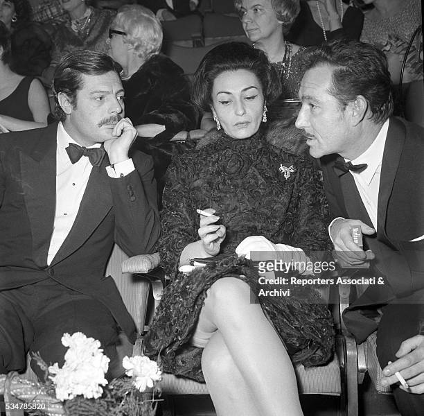 Italian actor Marcello Mastroianni attending the premiere of a film with his wife Flora Carabella and Italian actor Ugo Tognazzi. 1973