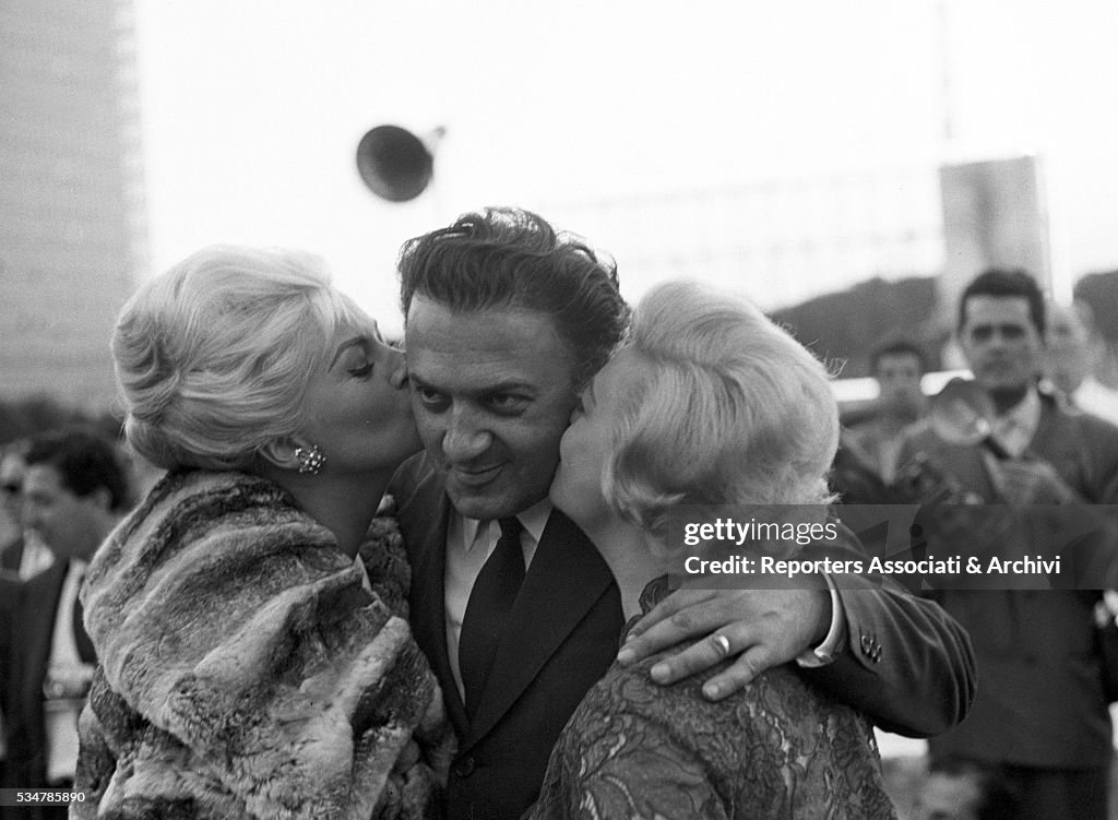 Giulietta Masina and Anita Ekberg kissing Federico Fellini