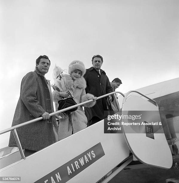 Italian actor Marcello Mastroianni, Italian director Federico Fellini and French actress Yvonne Furneaux boarding on the flight to London for the...