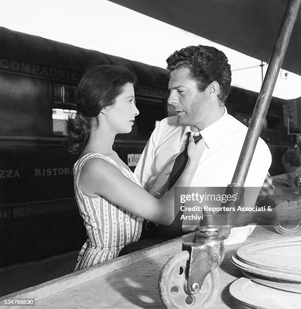 Italian actress Irene Galter tidying up Italian actor Marcello Mastroianni's tie at Tiburtina Railway Station during a break on the set of the film...