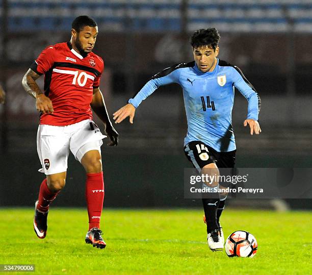 Shahdon Winchester of Trinidad & Tobago and Nicolas Lodeiro of Uruguay fight for the ball during an international friendly match between Uruguay and...