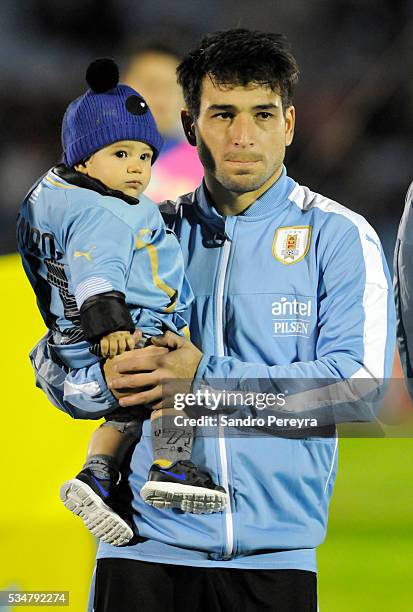 Nicolas Lodeiro of Uruguay carries his son before an international friendly match between Uruguay and Trinidad & Tobago at Centenario Stadium on May...