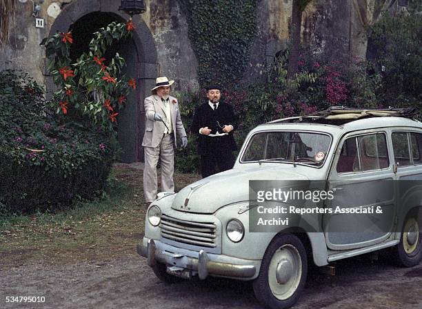 American actor Lionel Stander acting next to a car. Italy, 1974