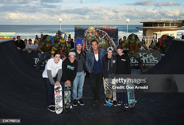 Stephen Amell and Will Arnett pose alongside skate-boarders during a photo call ahead of the Australian premiere of Teenage Mutant Ninja Turtles 2 on...