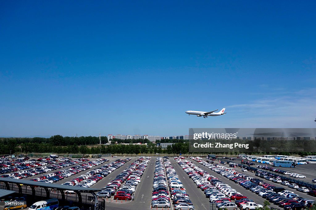A plane of Air China flies over a parking lot as it cones in...