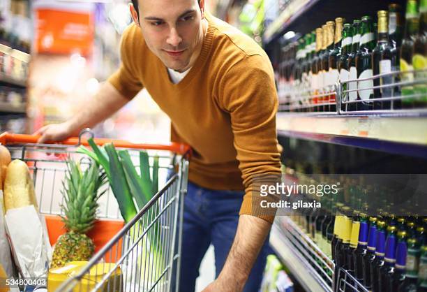 man buying beer in supermarket. - buying alcohol stock pictures, royalty-free photos & images