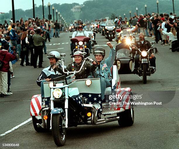 Rolling Thunder protest in D.C. This year, Miss America, Heather French, rode in protest. She is at right with fist in air as they cross the Memorial...