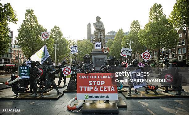 Photo taken on May 28, 2016 shows the statues of Rembrandt's Nachtwacht decorated with protest signs for a demonstration against the controversial...