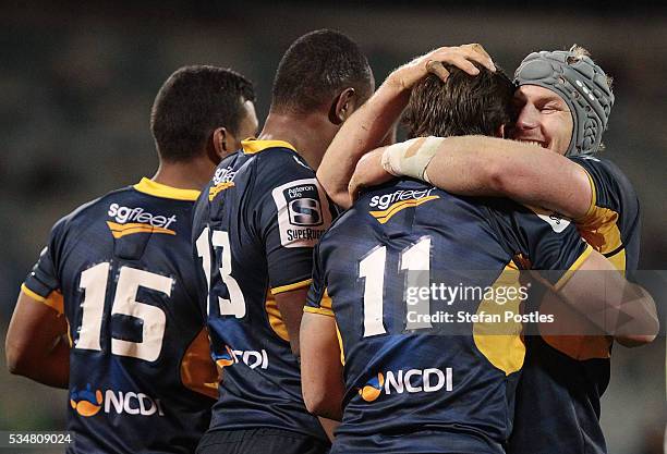 James Dargaville of the Brumbies celebrates with team mates after scoring a try during the round 14 Super Rugby match between the Brumbies and the...