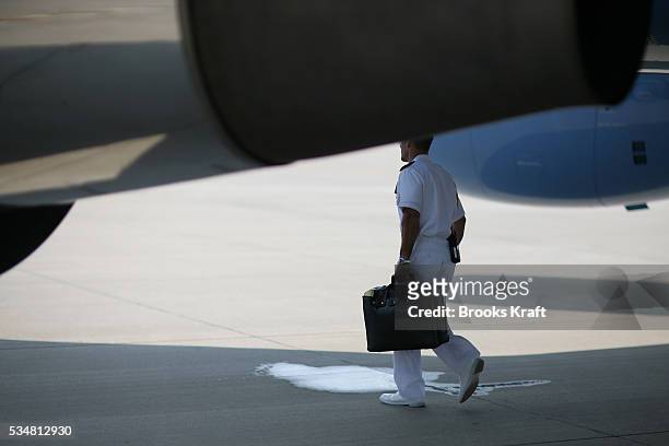 Military officer carries the "Football" under Air Force One at Andrews Air Force Base, July 26, 2006. The Football is a secure package that contains...